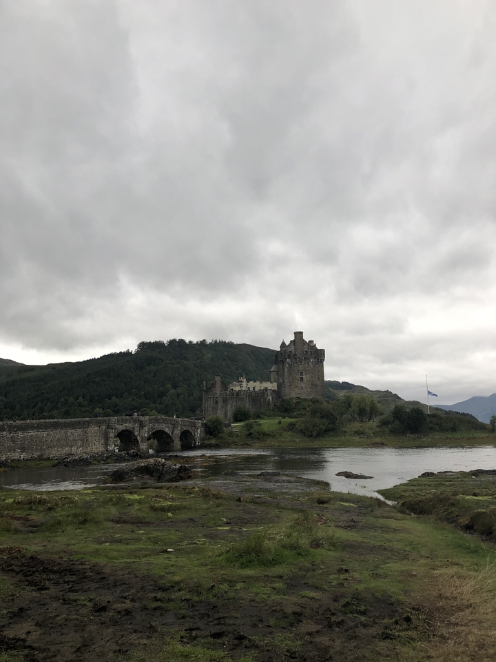 Eilean Donan Castle by a loch with cloudy sky.