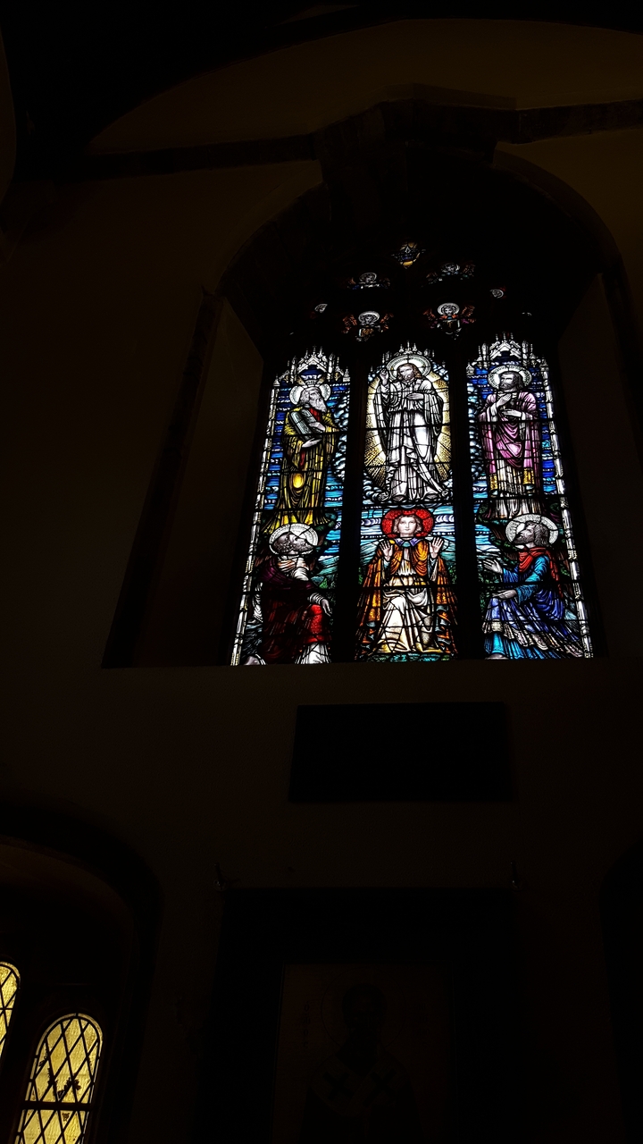 Vitrail représentant des figures religieuses et des motifs ornementaux.