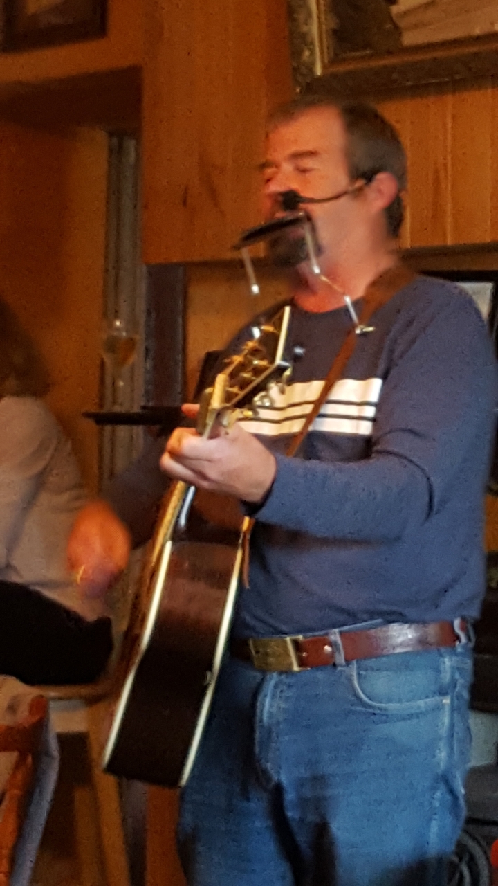 Gros plan flou d'une personne jouant de la guitare à l'intérieur.