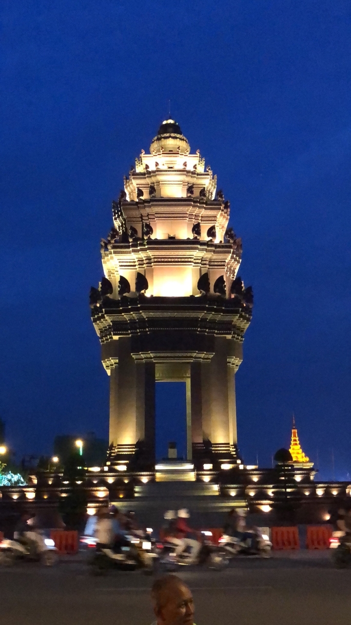 Tour de monument illuminée contre un ciel nocturne.
