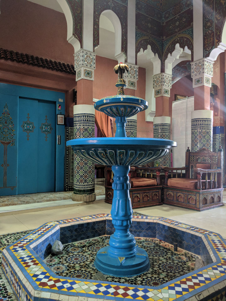 Intérieur richement décoré avec une fontaine et des sièges.