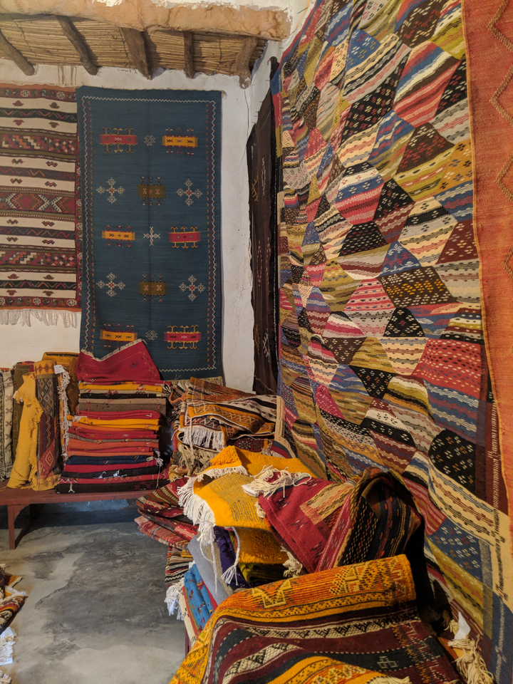 Tapis traditionnels colorés exposés sur un mur.