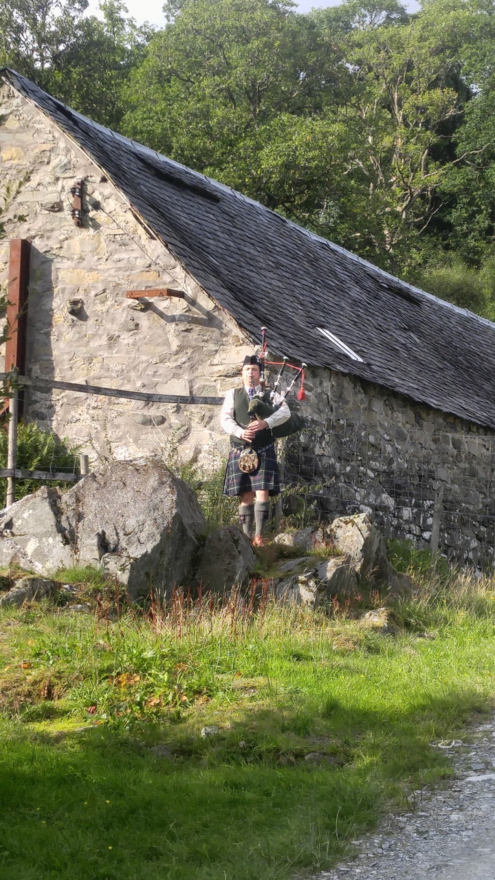 Une personne jouant de la cornemuse dans un cadre rural.