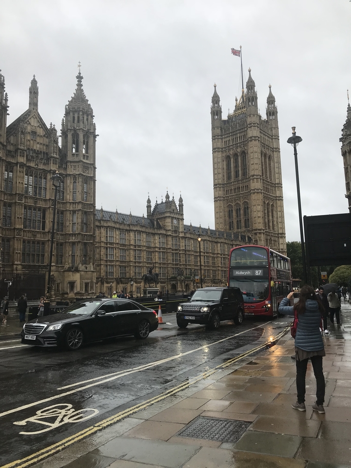 Une rue animée dans une ville européenne avec une architecture emblématique et un bus à impériale.