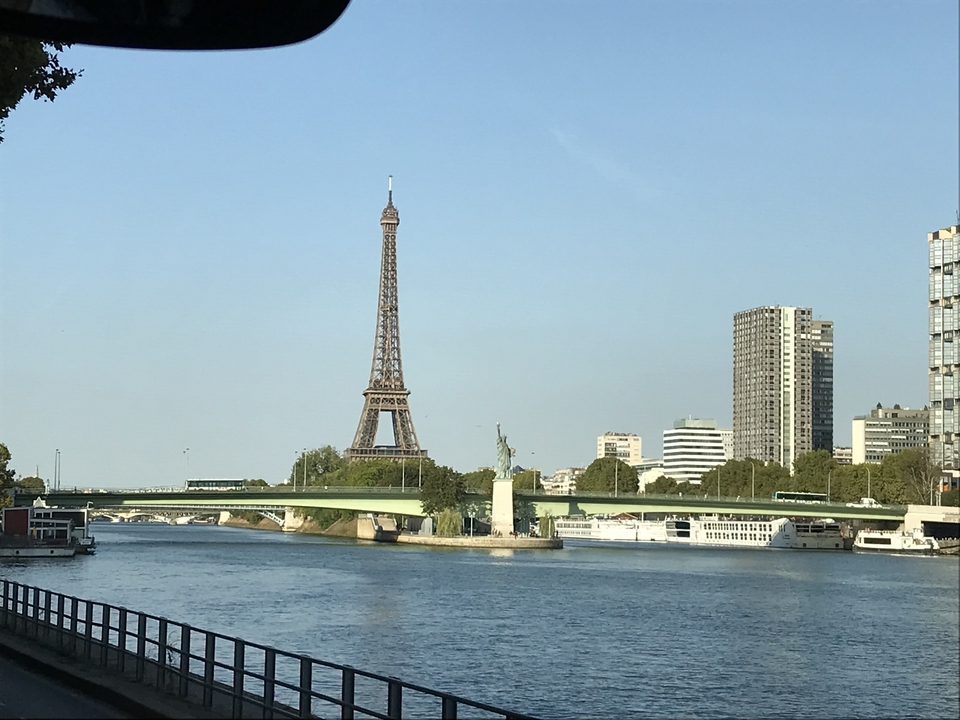 La Tour Eiffel et une vue sur la rivière par une journée ensoleillée.