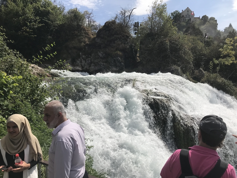 Des gens debout près d'une cascade.