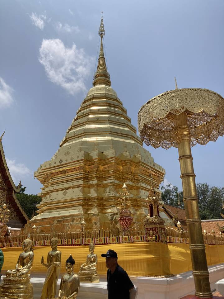 Structure de temple dorée avec une personne au premier plan.
