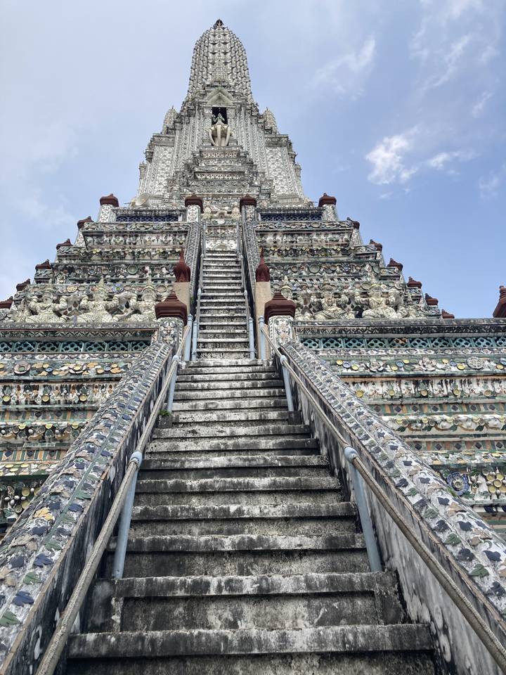 Grand temple de pierre aux détails complexes avec des marches qui y mènent.
