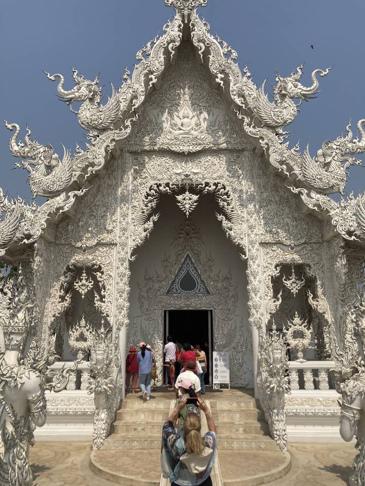 Temple blanc au design complexe avec des touristes.