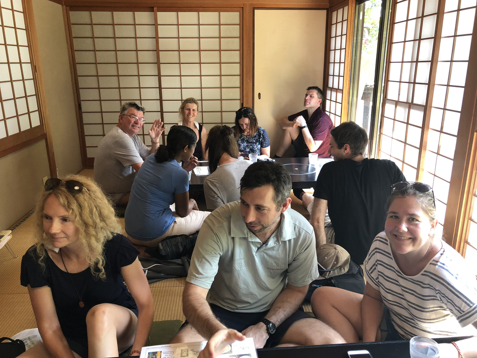 Groupe de personnes assises dans une chambre japonaise traditionnelle.