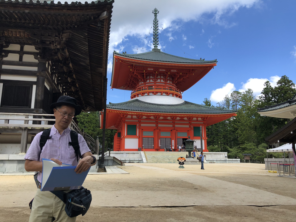 Personne lisant devant une grande pagode dans un cadre de temple.