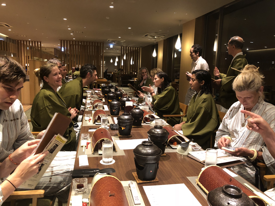 Groupe de personnes dînant dans un cadre traditionnel.