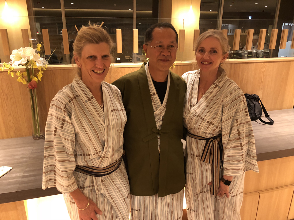 Trois personnes portant des yukatas traditionnels à l'intérieur.