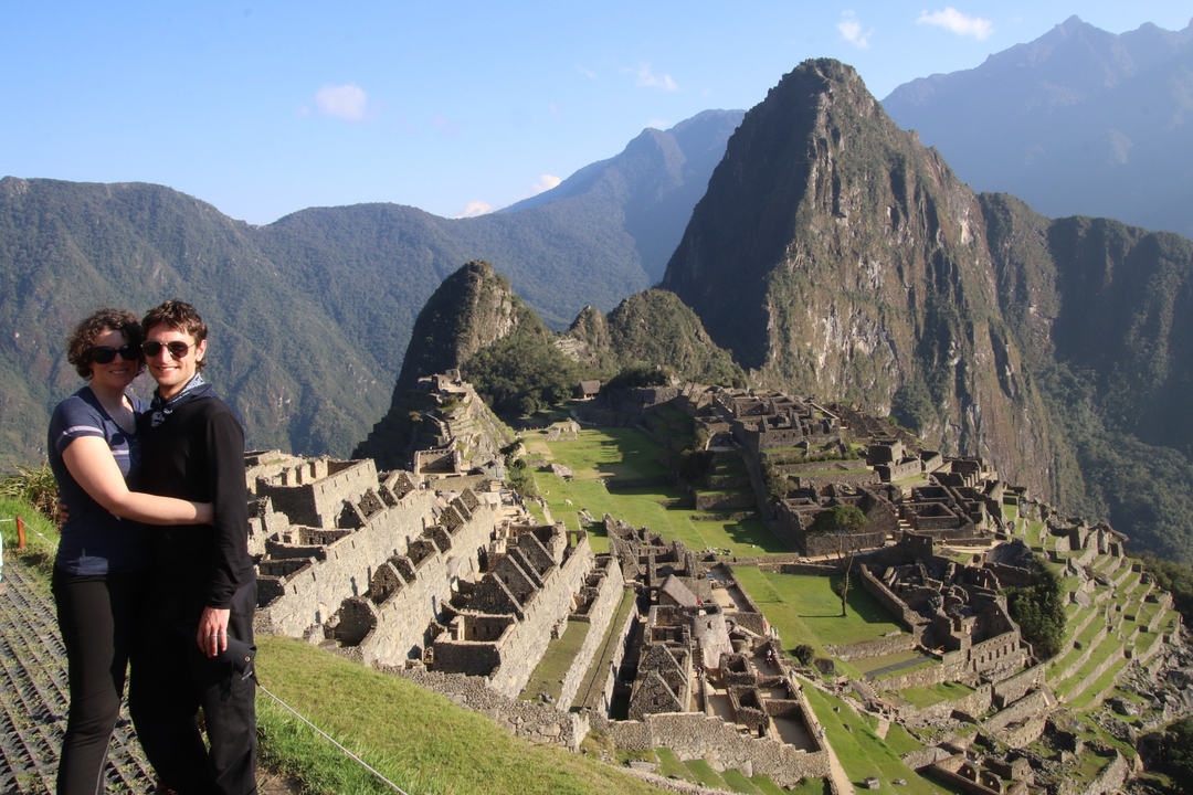Touristes posant avec les ruines du Machu Picchu en arrière-plan.