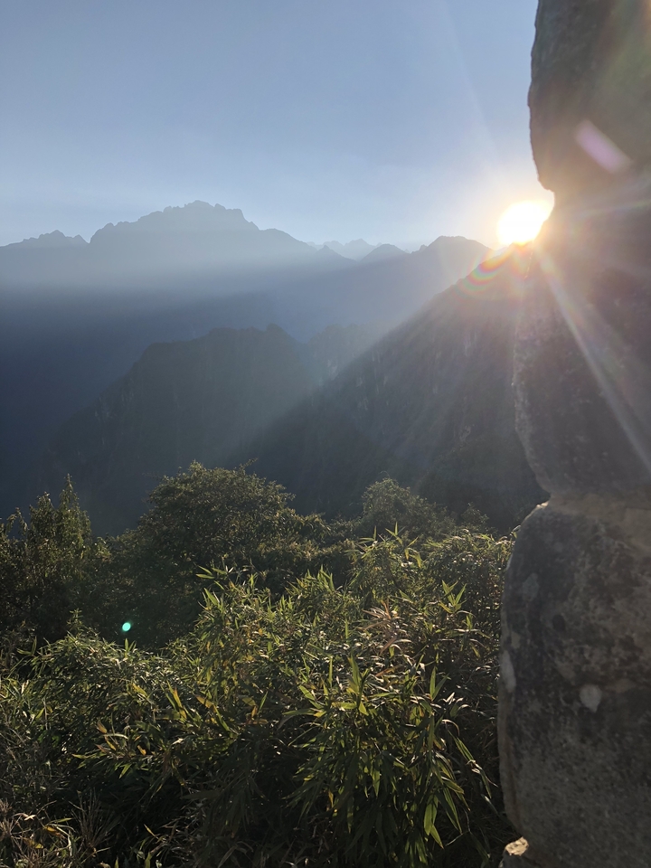 Soleil qui brille sur un paysage montagneux.