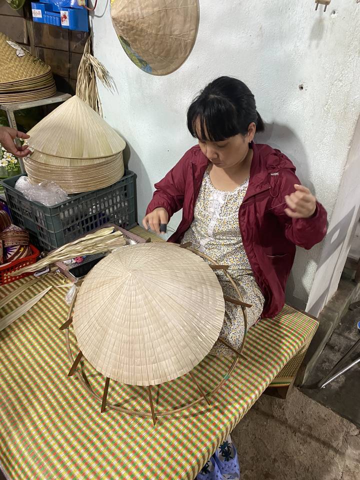 Femme confectionnant des chapeaux vietnamiens traditionnels.