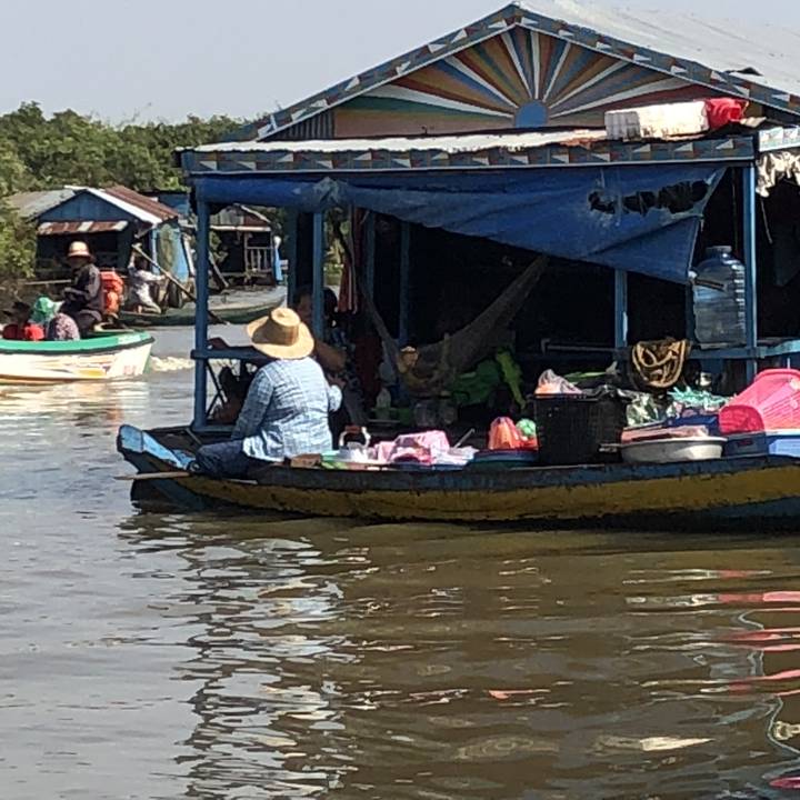 Personne portant un chapeau sur un bateau sur une rivière.