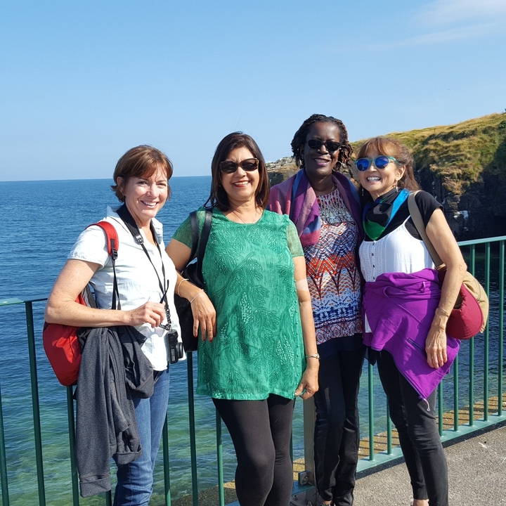 Groupe de femmes posant devant une vue côtière.