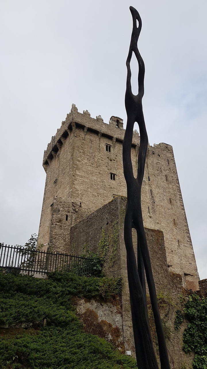 Tour de pierre historique avec sculpture moderne.