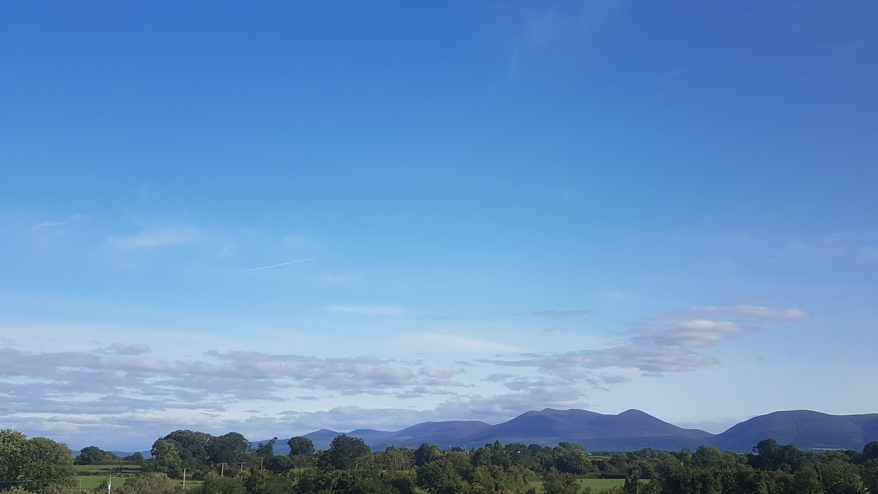 Campagne avec des montagnes en arrière-plan.