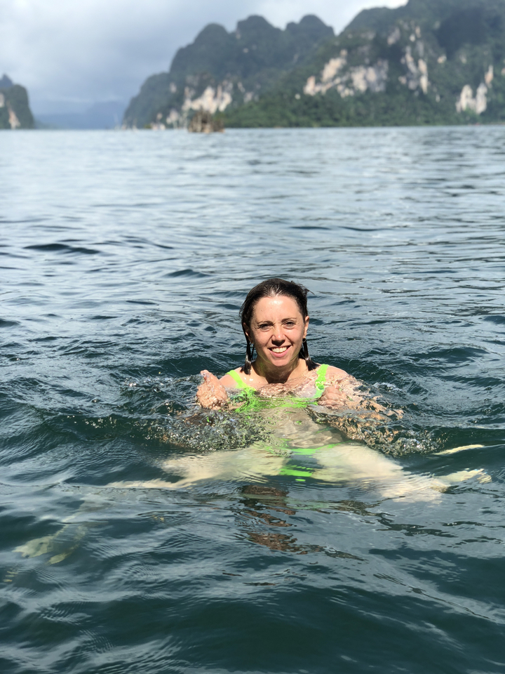 Femme souriante nageant dans l'eau.