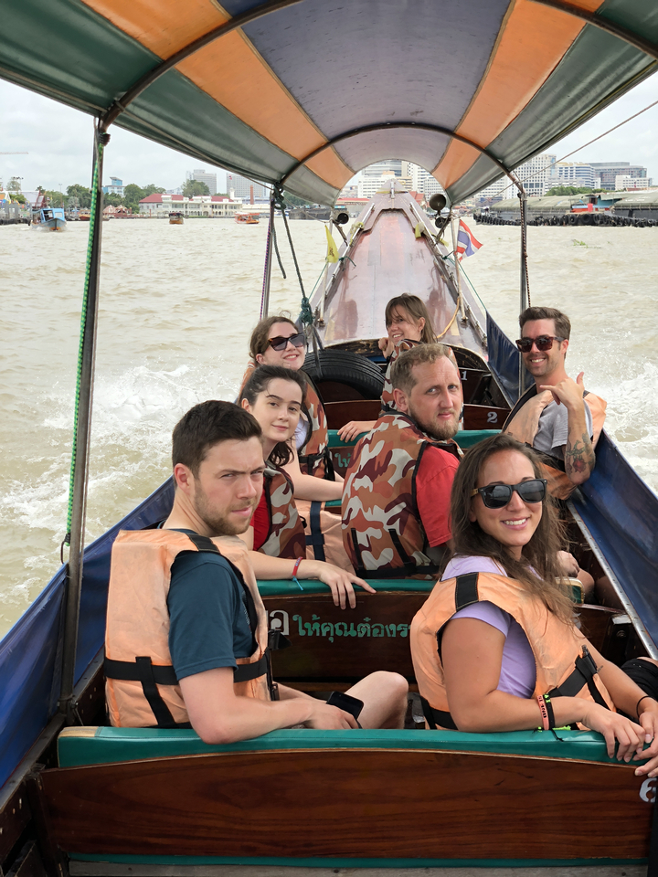 Groupe de personnes portant des gilets de sauvetage sur un bateau.
