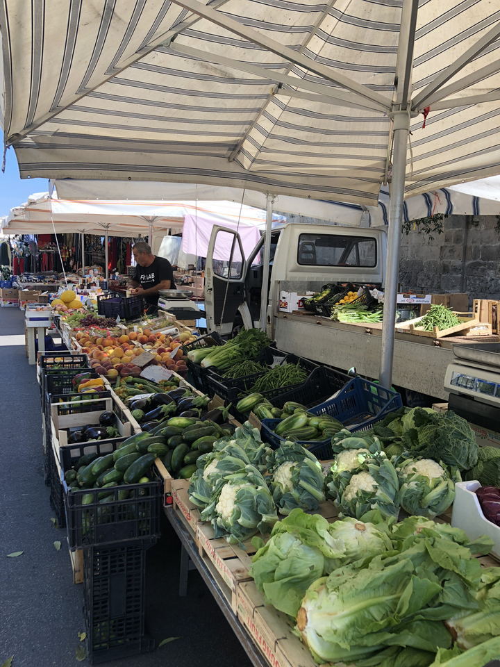 Étal de marché avec une sélection de fruits et légumes.