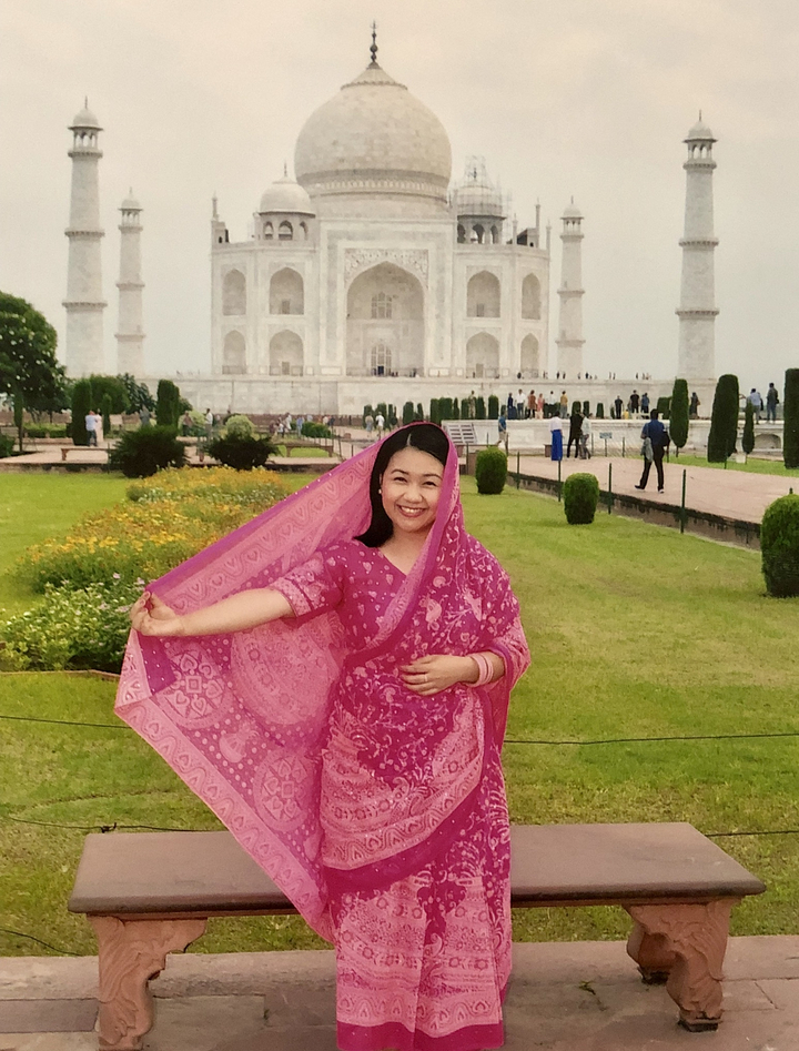 Femme en costume traditionnel devant un célèbre bâtiment en marbre blanc.