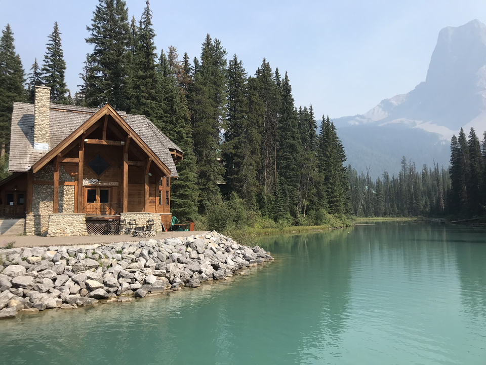 Cabane en bois au bord d'un lac calme dans les montagnes.