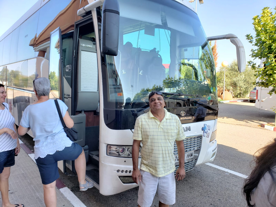 Personne devant un autocar de tourisme.