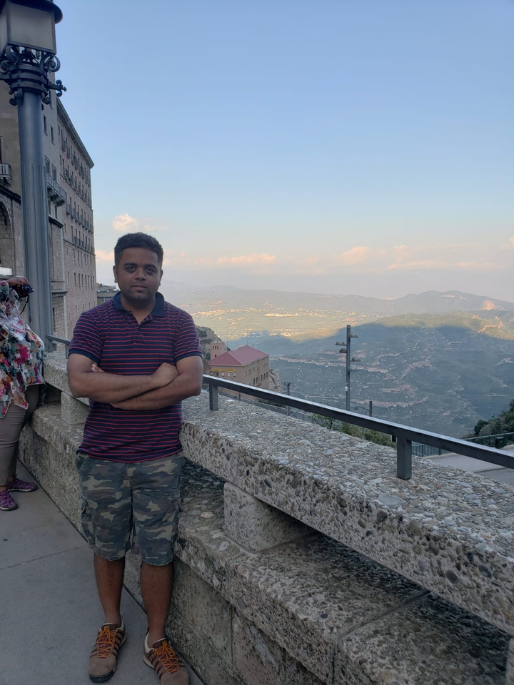 Personne posant avec un paysage montagneux.