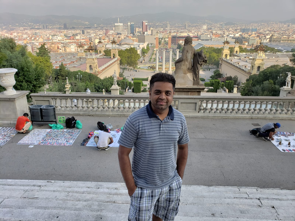 Homme posant avec un paysage urbain et des sculptures.