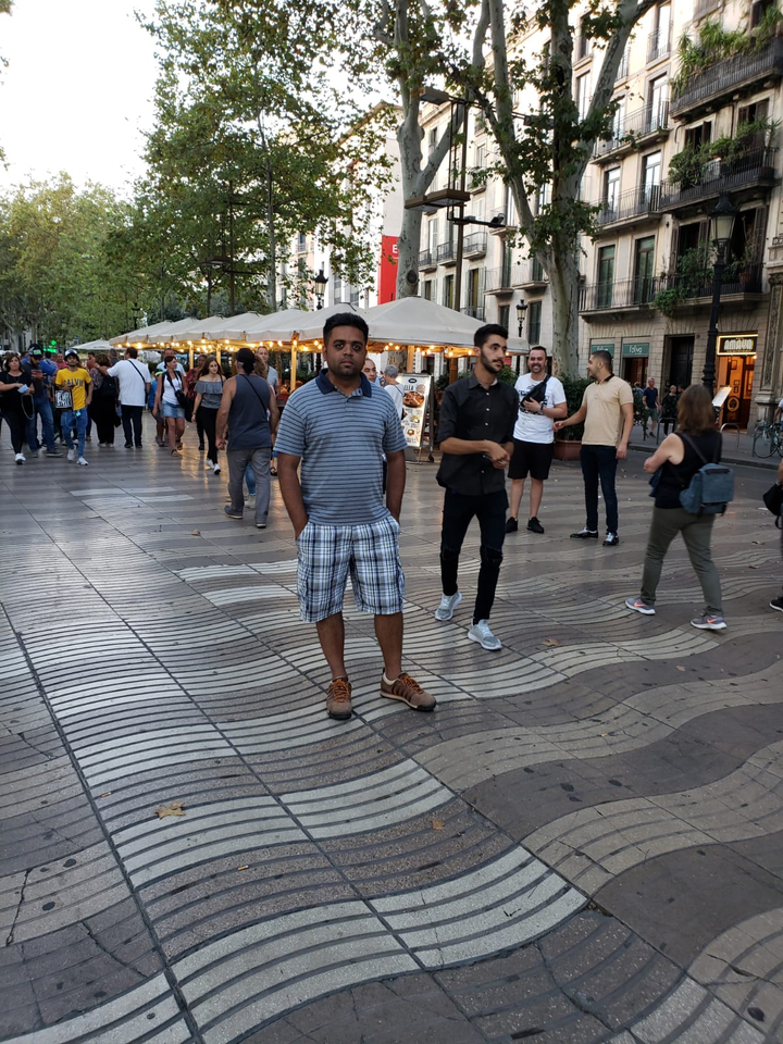 Rue bondée avec un piéton qui pose.