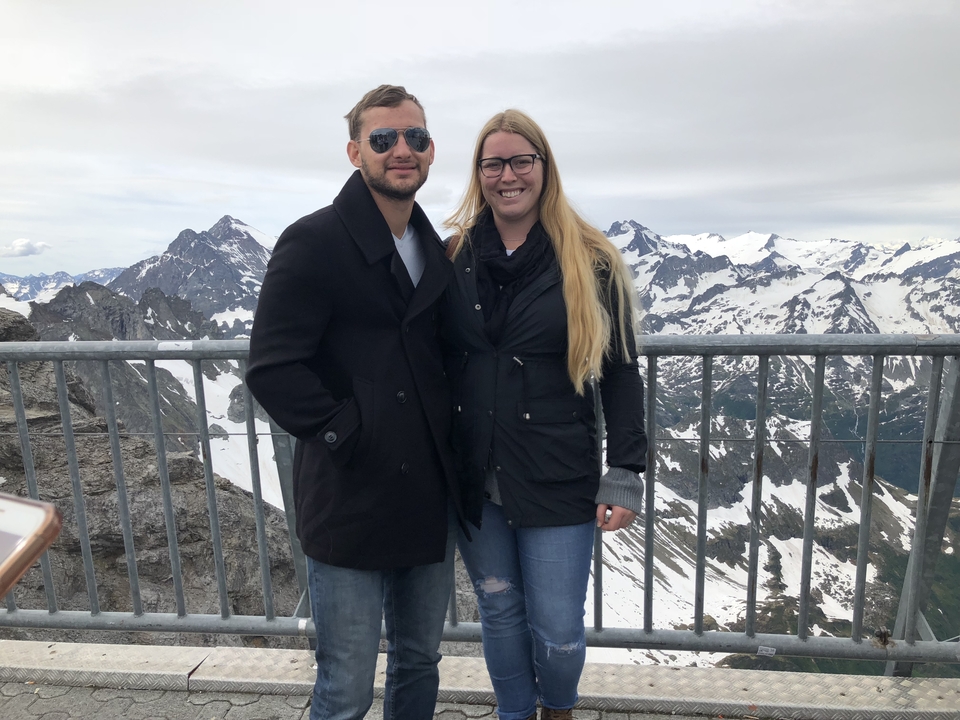 Couple posant sur une plateforme d'observation en montagne.