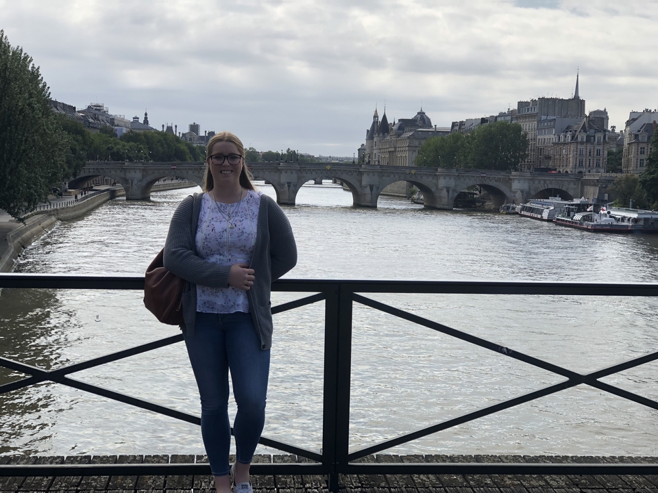 Femme debout sur un pont avec vue sur la rivière.