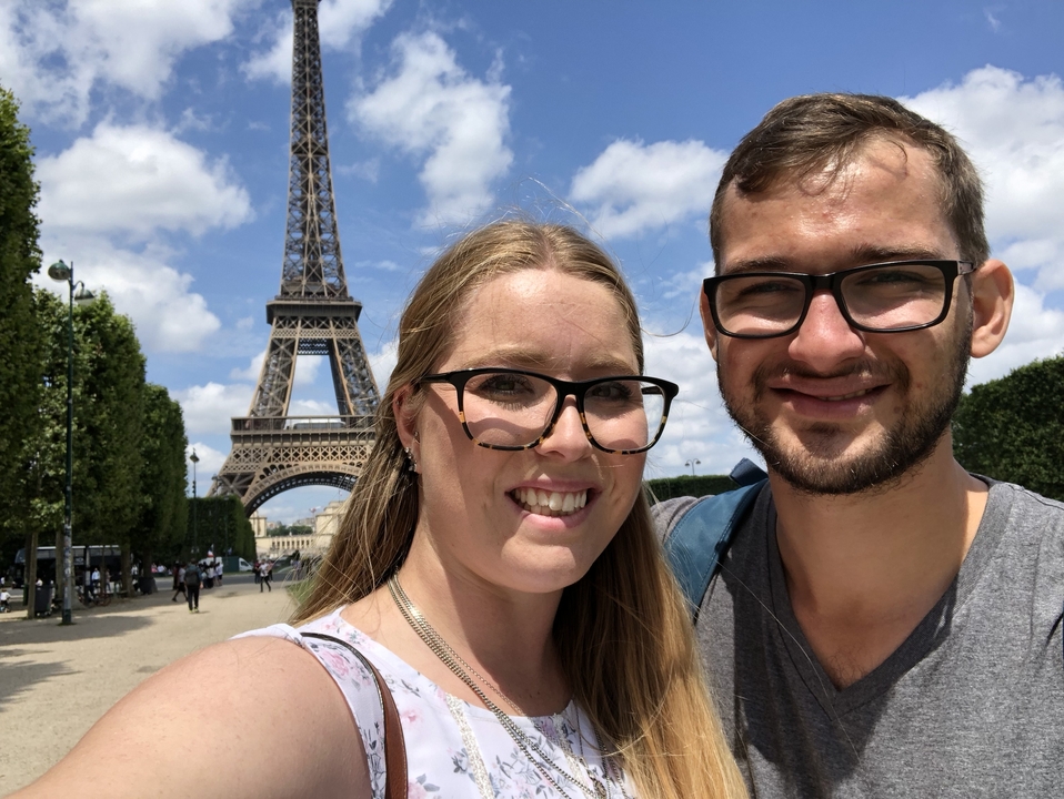 Couple posant avec la tour Eiffel en arrière-plan.