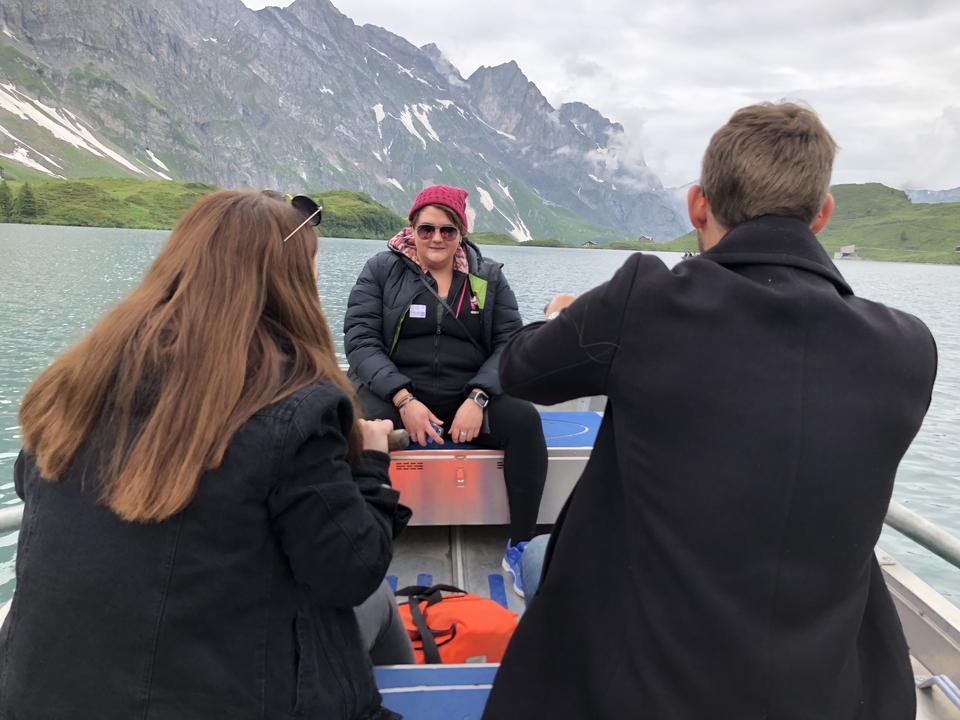Des gens sur un bateau dans un lac de montagne.