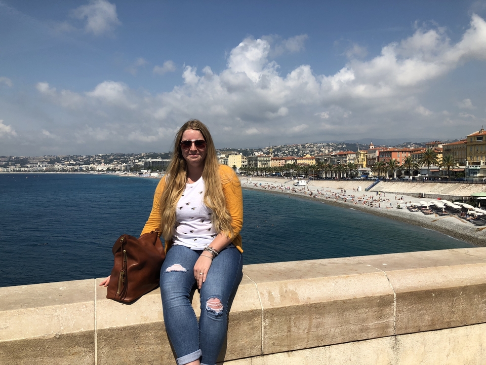 Femme assise au bord de la mer dans une ville côtière.