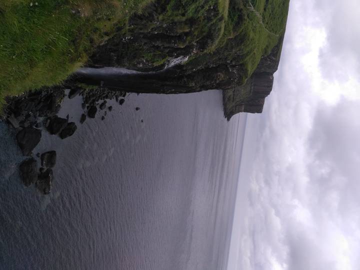 Cliffs overlooking a body of water with overcast skies.