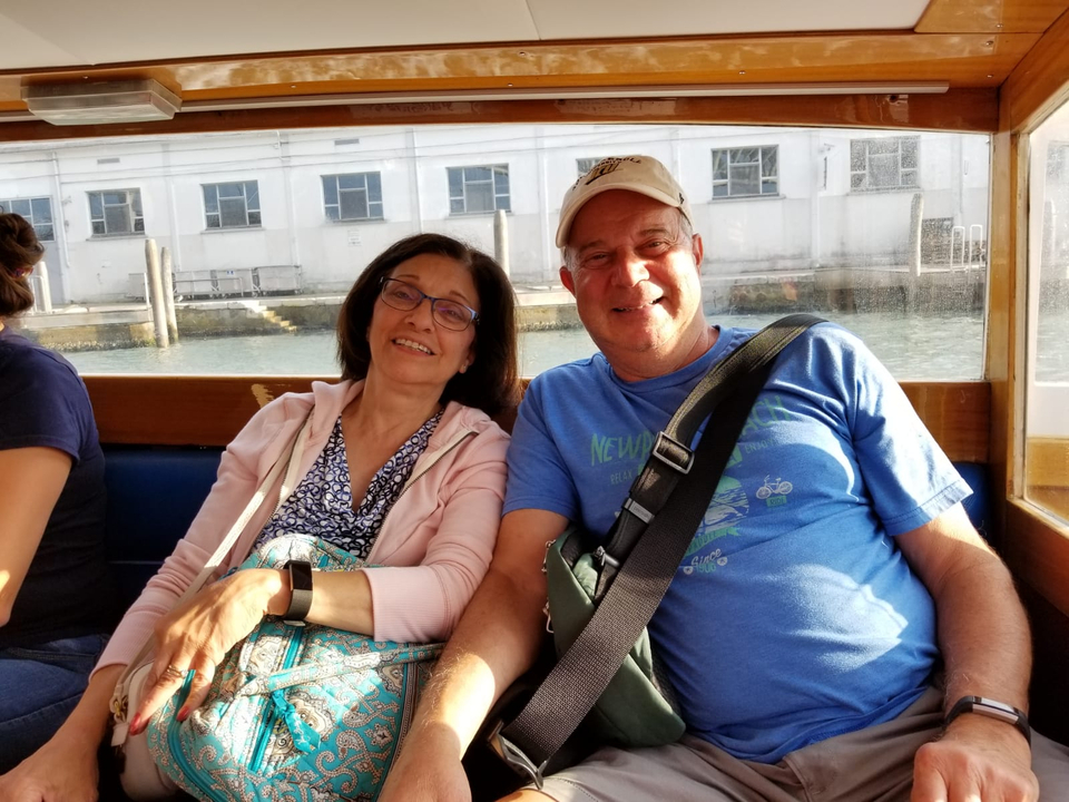 Couple assis à l'intérieur d'un bateau avec une vue sur l'eau à l'extérieur.