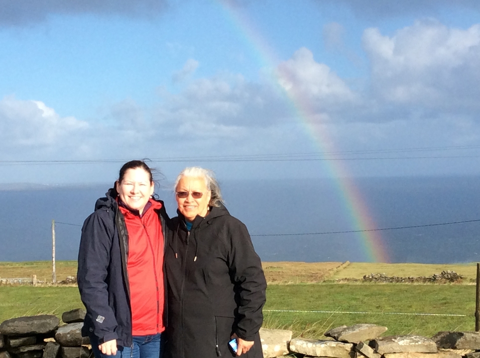 Deux femmes avec un arc-en-ciel en arrière-plan.