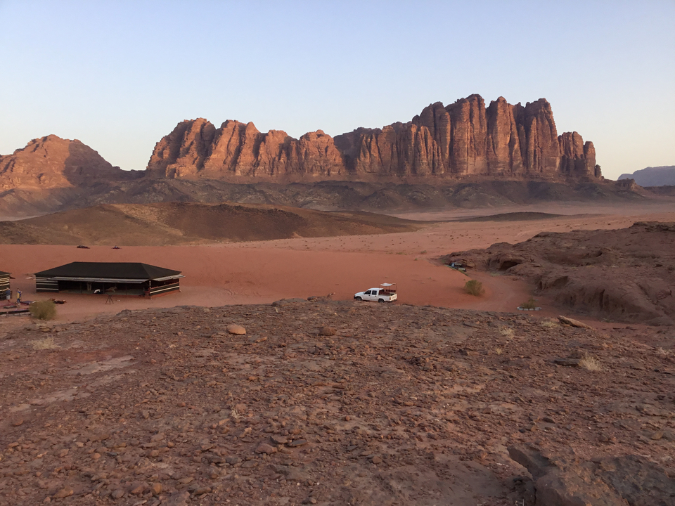 Paysage désertique avec des formations rocheuses et une tente.
