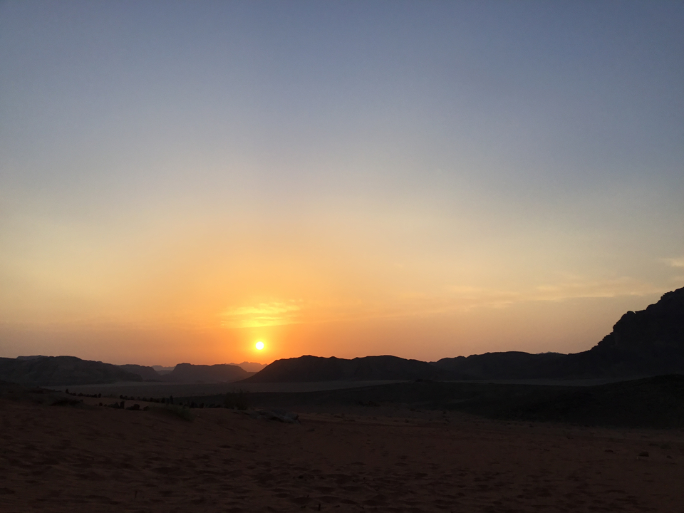 Coucher de soleil sur un paysage désertique montagneux.