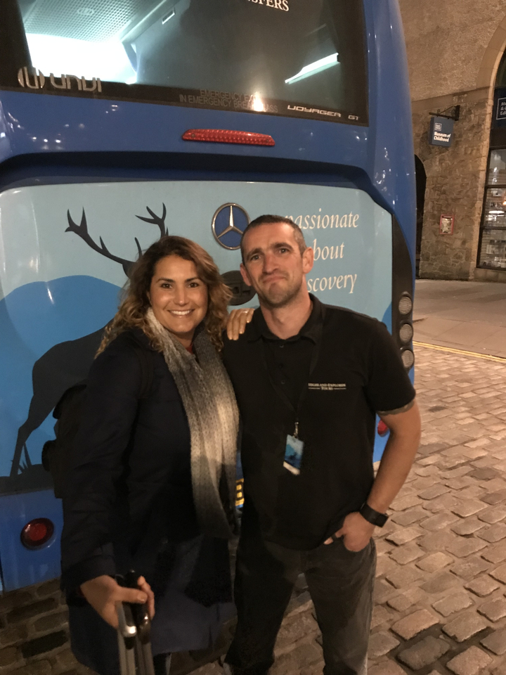 Deux personnes debout devant un bus avec une illustration de cerf dessus.