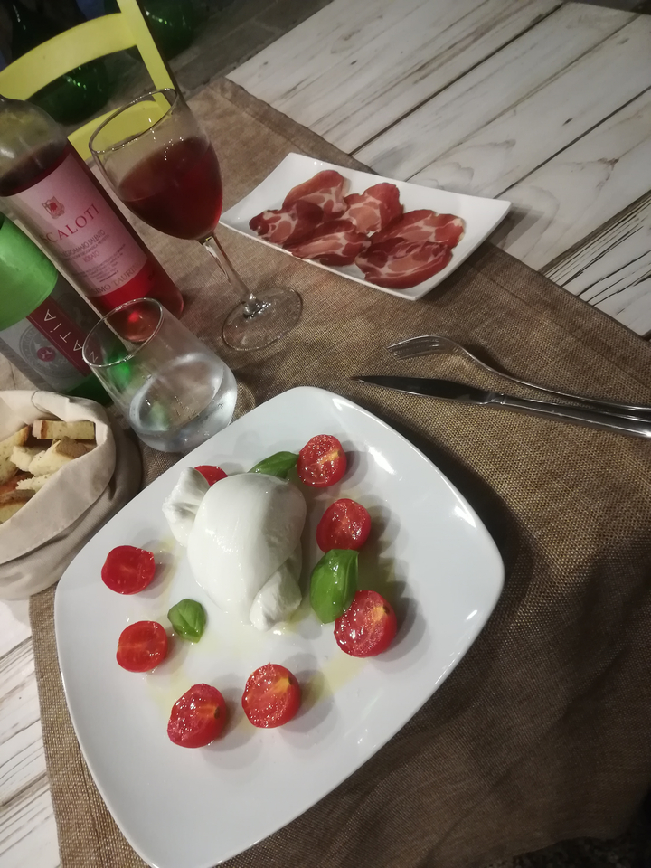 Assiette de mozzarella et tomates avec du vin.