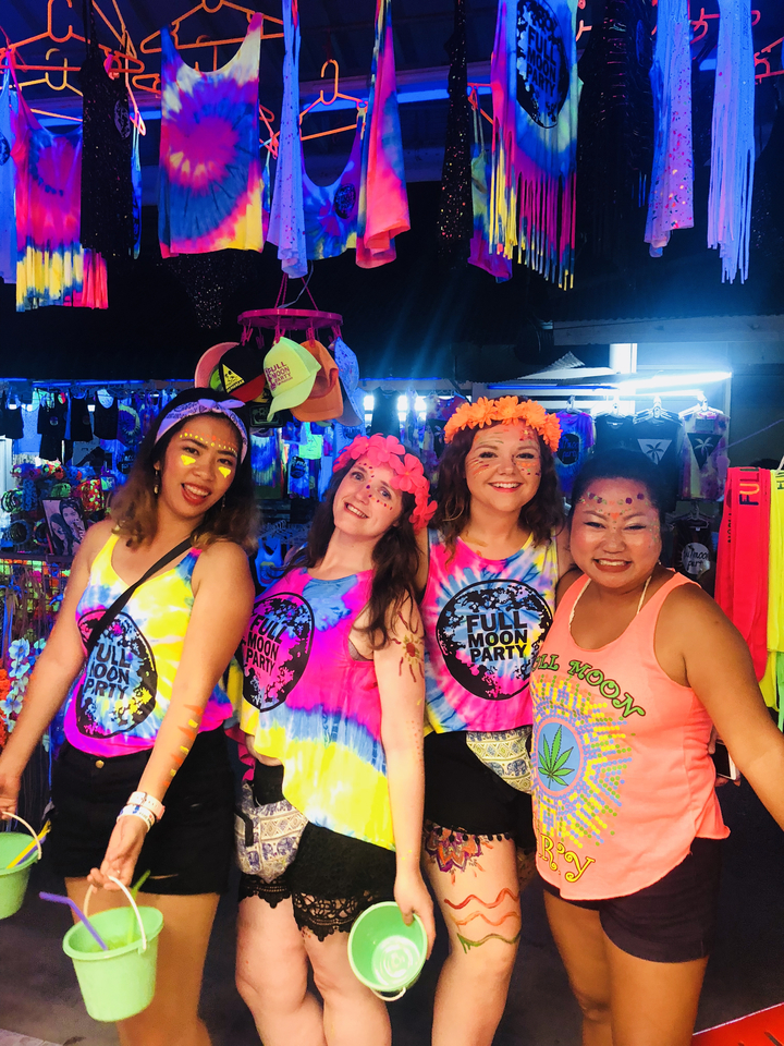 Groupe de personnes à une Full Moon Party portant des tenues colorées.