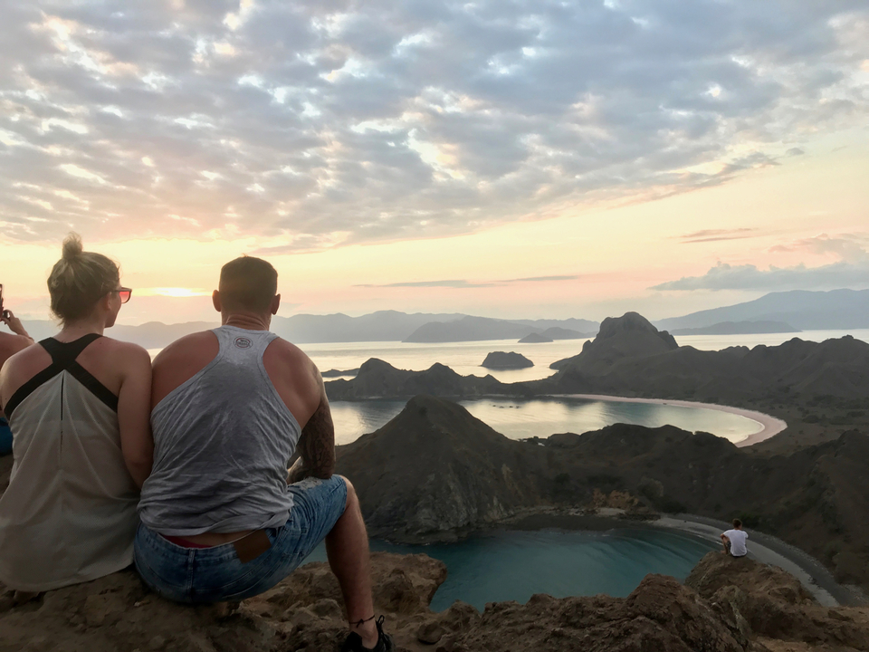Couple overlooking a scenic viewpoint during sunset.