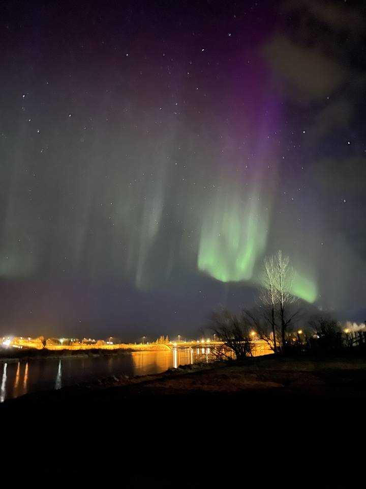 Northern lights display over a town at night
