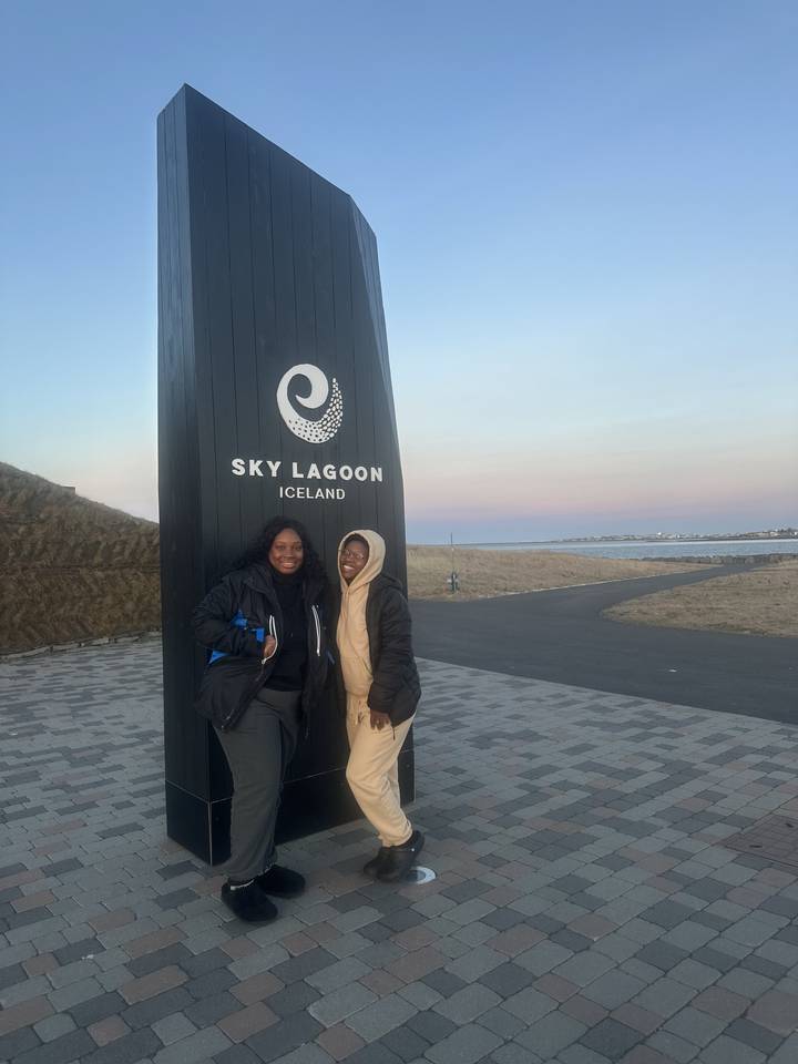 Two people posing with a Sky Lagoon sign.