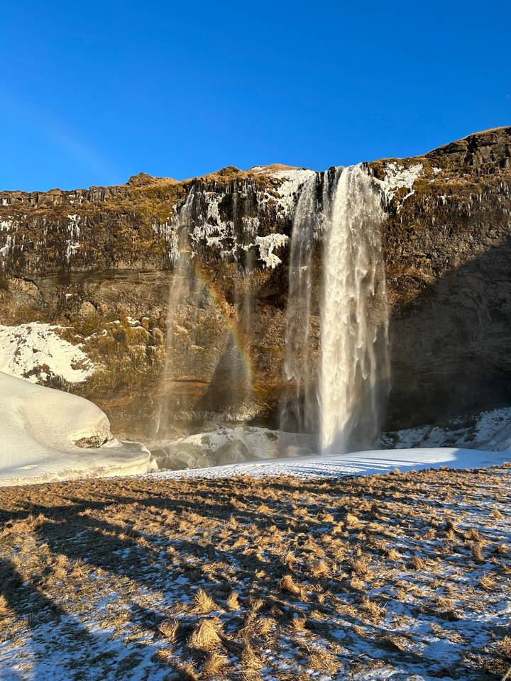 Large picturesque waterfall with a faint rainbow beneath.